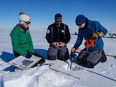  Manually measuring the snow and ice thickness.